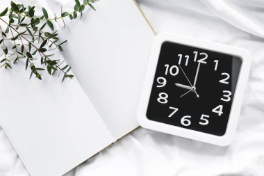 Yatakta zarif saat ve defter