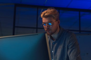 Geceleri ofiste çalışan yakışıklı adam.