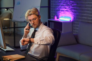 Geceleri ofiste çalışan yakışıklı adam.