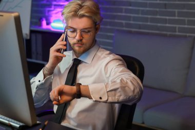 Geceleri ofiste çalışan yakışıklı adam.