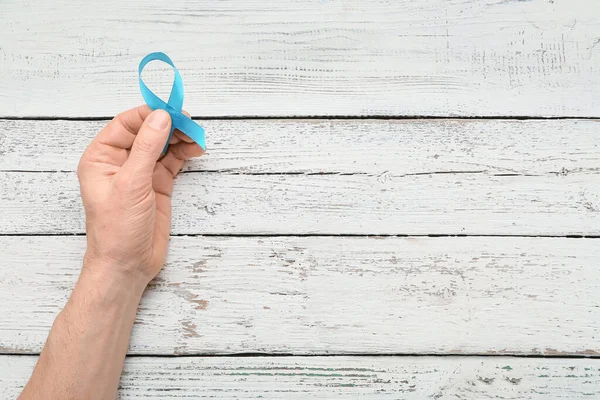Male Hand Light Blue Ribbon Wooden Background Prostate Cancer Concept — Stock Photo, Image