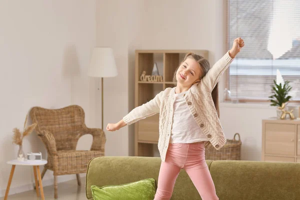 快乐的小女孩在家里的沙发上跳舞 — 图库照片