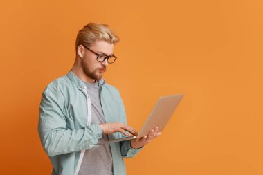 Arkaplanda dizüstü bilgisayar kullanan yakışıklı bir adam