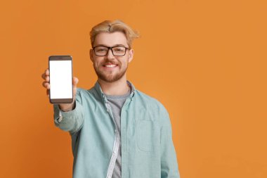 Renkli arka planda cep telefonu olan yakışıklı bir adam