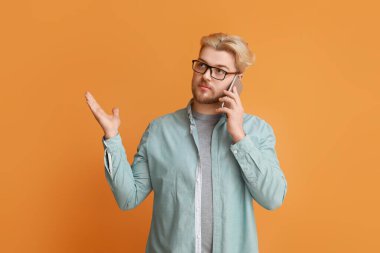 Renkli arka planda cep telefonuyla konuşan yakışıklı adam