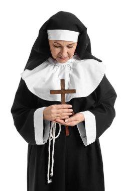 Beyaz arka planda haç çizen olgun bir rahibe