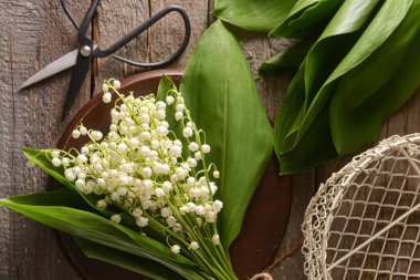 Ahşap arka planda güzel vadi zambakları olan tahta.