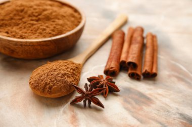 Renkli arkaplanda tarçın tozu olan tabak ve kaşık