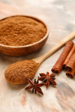 Renkli arkaplanda tarçın tozu olan tabak ve kaşık