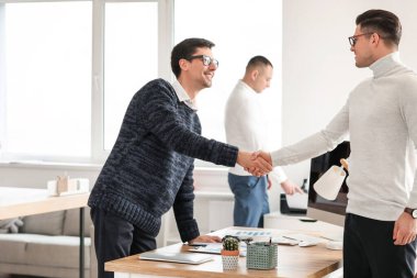 Erkek muhasebeci ve müvekkil ofiste el sıkışıyor