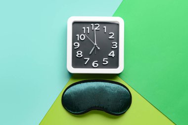 Renkli arkaplanda şık saat ve uyku maskesi