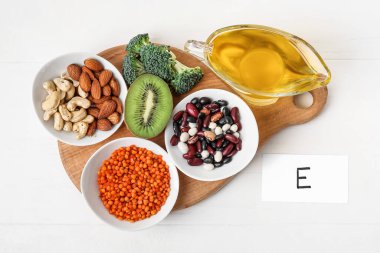 Açık ahşap zemin üzerinde E vitamini bakımından zengin sağlıklı ürünlere sahip tahta.
