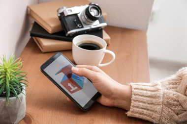 Dağıtım hizmeti başvurusunun açık sayfası olan cep telefonu tutan kadın, kapat