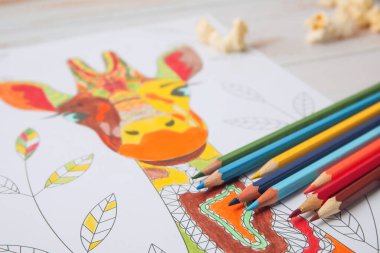 Ahşap arkaplanda resim ve kalemler, yakın plan