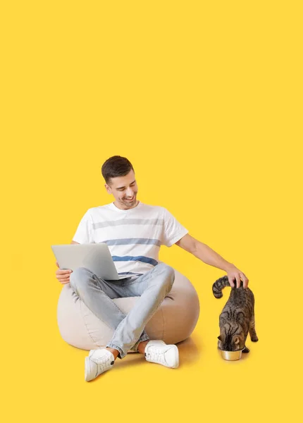 Mladý Muž Roztomilou Kočkou Pomocí Notebooku Barevném Pozadí — Stock fotografie
