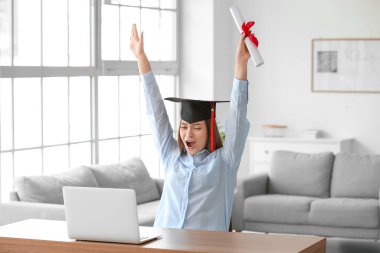Mezuniyet gününde evde mutlu bir bayan öğrenci. Çevrimiçi öğrenim kavramı