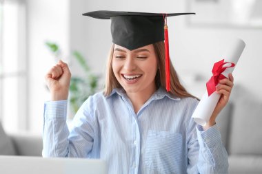Mezuniyet gününde evde mutlu bir bayan öğrenci. Çevrimiçi öğrenim kavramı