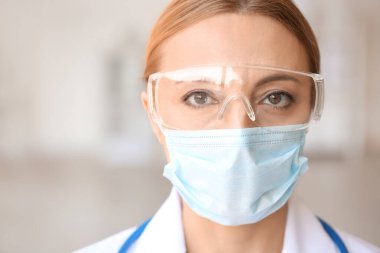 Klinikte koruyucu üniformalı kadın doktor portresi.