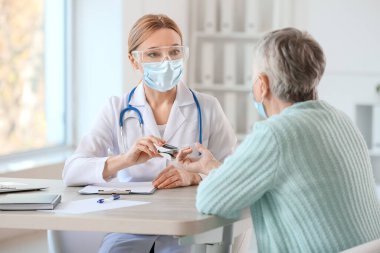 Klinikteki hastanın kanının oksijen doygunluğunu ölçen doktor.