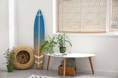 Sörf tahtası ve ev bitkileriyle dolu bir masa.