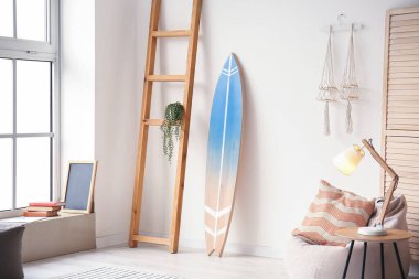 Sörf tahtası olan modern bir odanın içinde.