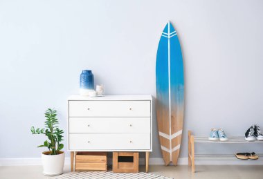 Sörf tahtası, ayakkabı standı ve çekmeceleri olan modern bir salon.