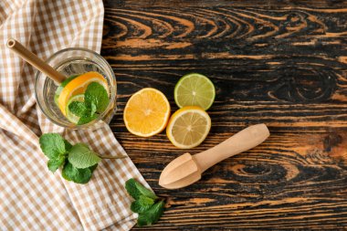 Bir bardak sağlıklı limonata ve ahşap arka planda sıkma.