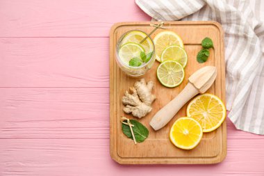 Bir bardak sağlıklı limonata ve ahşap arka planda sıkma.