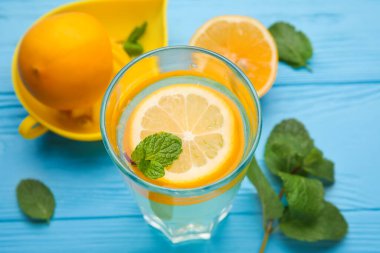 Bir bardak sağlıklı limonata ve ahşap arka planda sıkma.