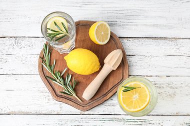 Sağlıklı limonata bardakları, limonlar ve hafif ahşap arka planda sıkma.
