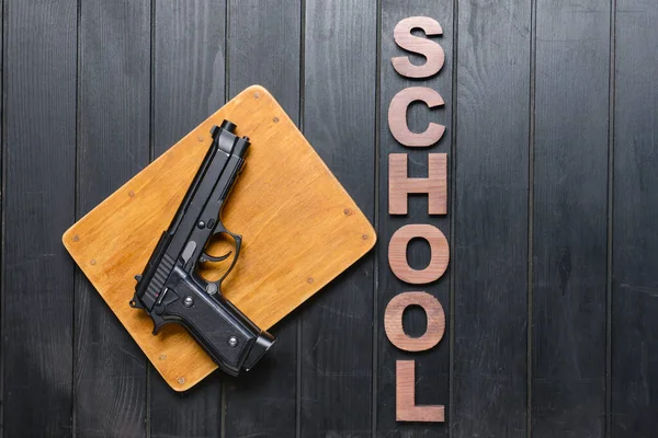 暗い木製の背景にピストル 学校撮影の概念 — ストック写真