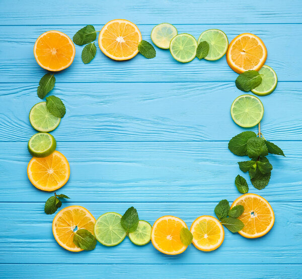 Frame made of healthy citrus fruits on color wooden background