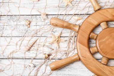 Tahta zemin üzerinde dümen, ağ ve deniz kabukları