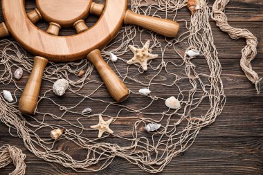 Tahta zemin üzerinde dümen, ağ ve deniz kabukları
