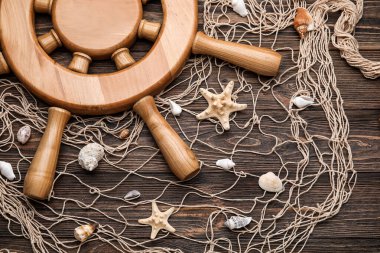 Tahta zemin üzerinde dümen, ağ ve deniz kabukları