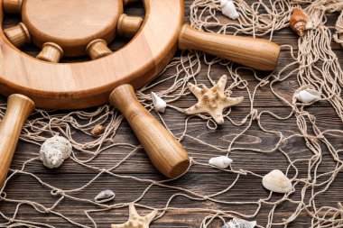 Tahta zemin üzerinde dümen, ağ ve deniz kabukları