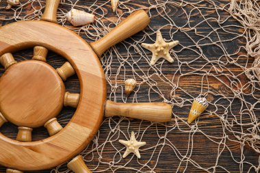 Tahta zemin üzerinde dümen, ağ ve deniz kabukları