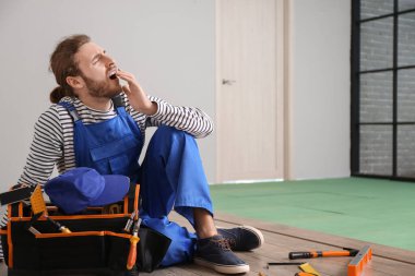 Odaya döşeme döşenirken yorgun marangoz