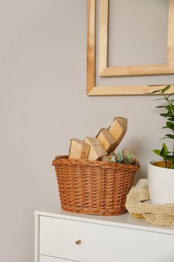 Rafta odun dolu sepet, ışık duvarının yanında.