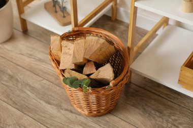 Odanın zemininde odun dolu sepet.