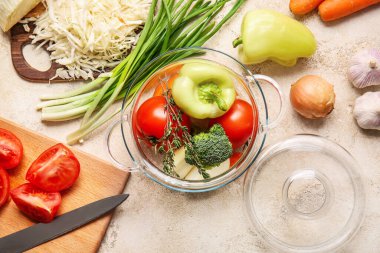 Hafif arka planda taze sebzeli, şık bir tencere.