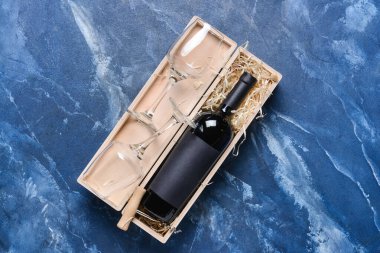 Renkli arka planda şarap ve bardak dolu bir kutu.