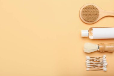 Renk arkaplanına pamuk çubukları, fırçalar ve bir şişe kozmetik ürün