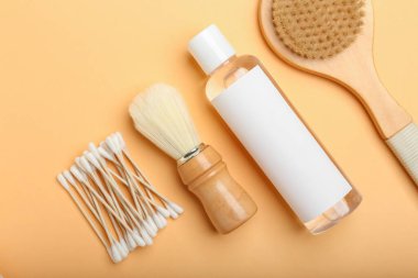 Renk arkaplanına pamuk çubukları, fırçalar ve bir şişe kozmetik ürün
