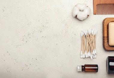 Hafif arkaplanda pamuklu çubuklar, çiçek ve kozmetik ürünleri ile kompozisyon