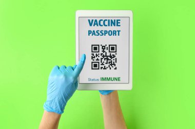 Elektronik bağışıklık sistemine sahip eller renk arkaplanına karşı tablet bilgisayarın ekranında