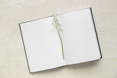 Boş bir kitap ve açık arkaplanda güzel bir zambak.