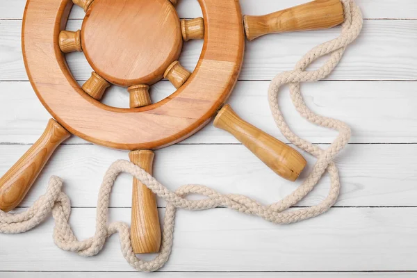 Dümen ve halat beyaz ahşap arka planda