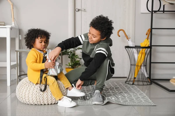 African American Boy Tying Sister Shoelaces Home — Stock Photo, Image