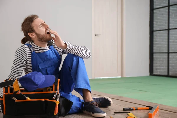 Odaya döşeme döşenirken yorgun marangoz